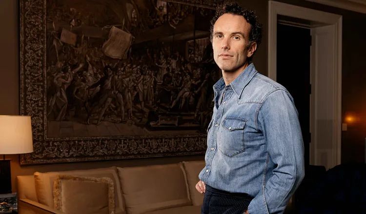 Elliot Ackerman stands confidently in a room beside a historic tapestry, illustrating themes of personal presence, confidence, communication, and self-presentation explored in A Man Should Know: How to Introduce Himself.