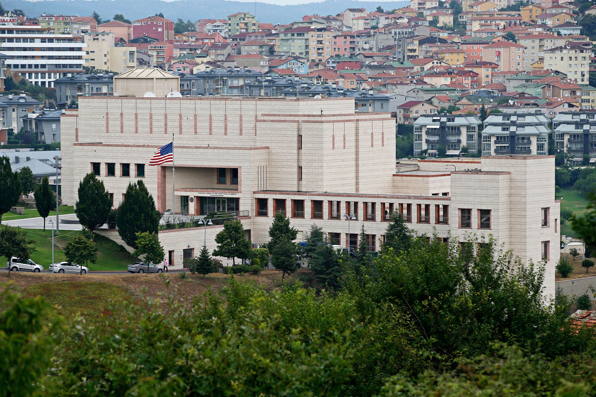 The U.S. Consulate General building in Istanbul, a fortress-like structure with an American flag, overlooking the city.