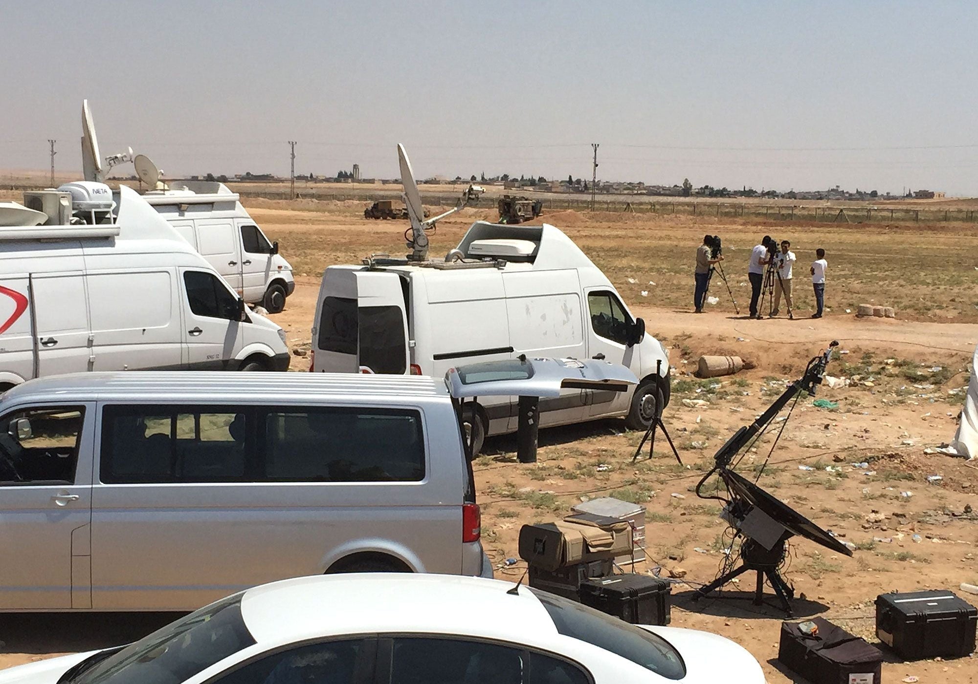 News vans and camera crews gather at the Turkish-Syrian border near Tal Abyad.