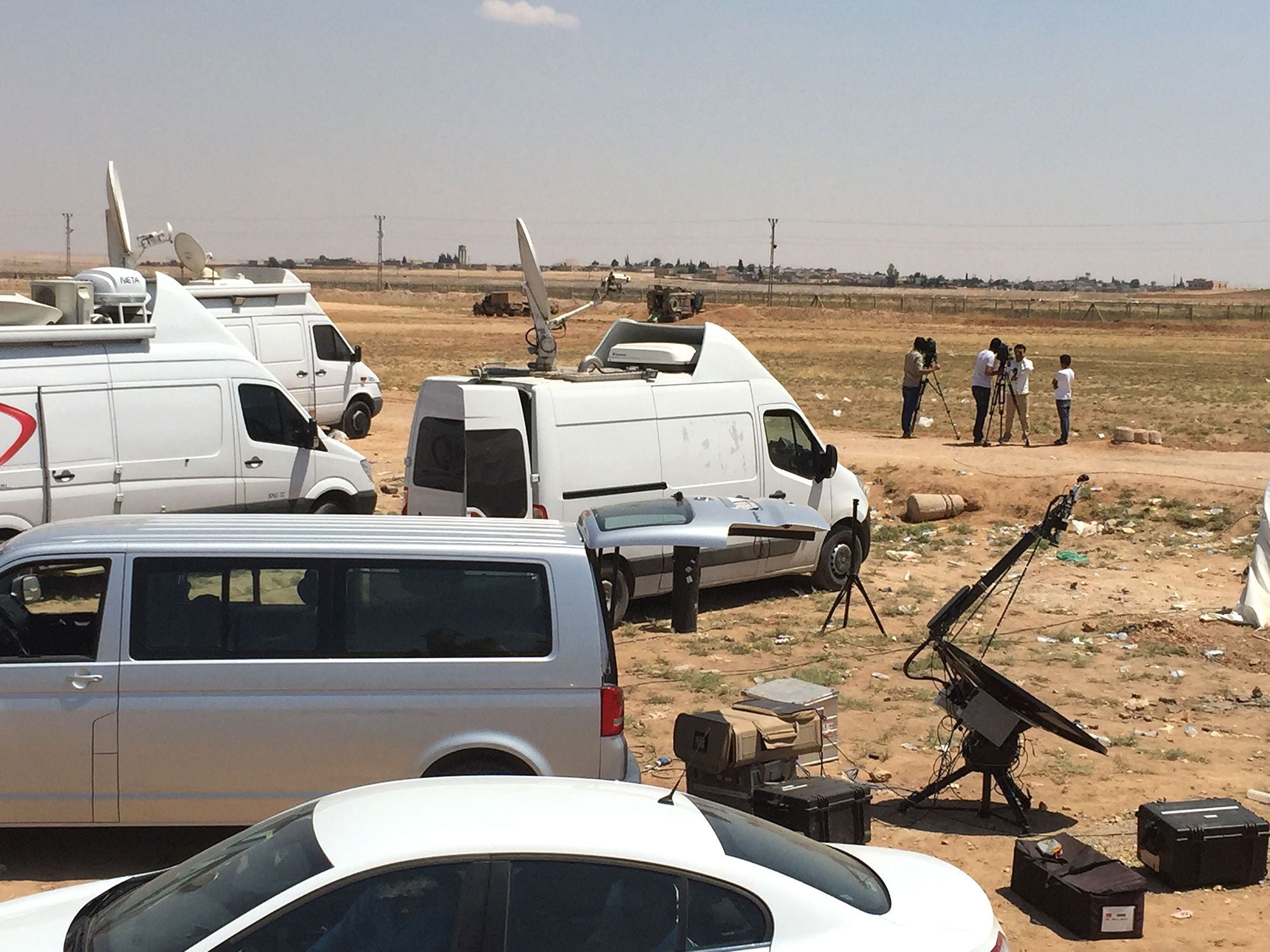 News vans and camera crews gather at the Turkish-Syrian border near Tal Abyad.