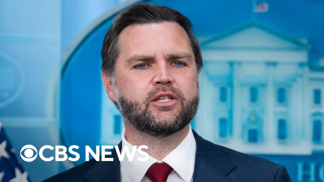 JD Vance speaking at a White House press briefing during CBS News coverage of the U.S.-Iran conflict.