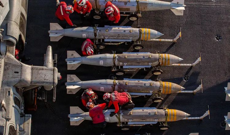 Navy sailors handle ordnance on the flight deck of the USS Abraham Lincoln during Operation Epic Fury on February 28, 2026.