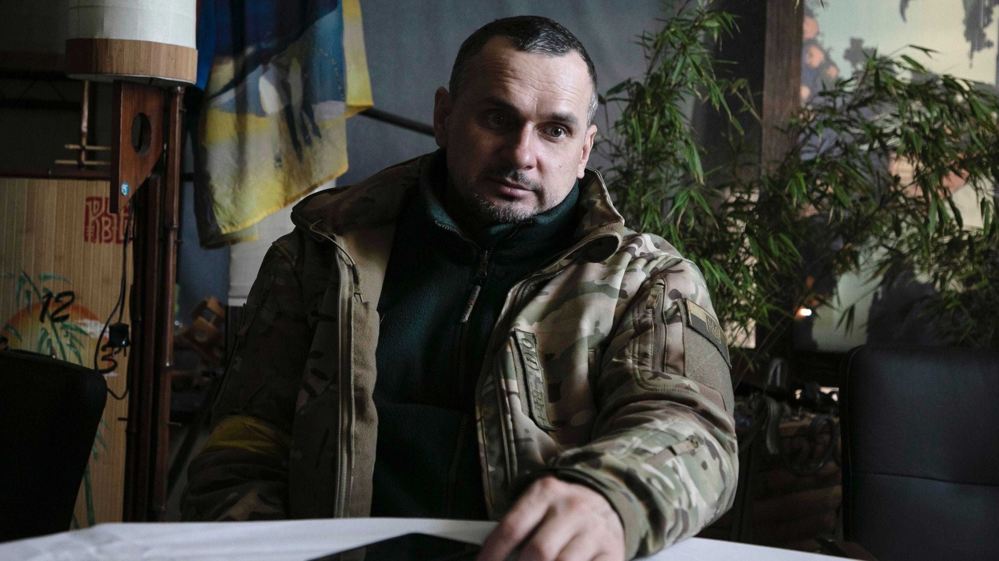 Ukrainian filmmaker and former political prisoner Oleh Sentsov, dressed in military clothing, sits indoors during an interview while serving in Ukraine’s territorial-defense forces amid Russia’s invasion.
