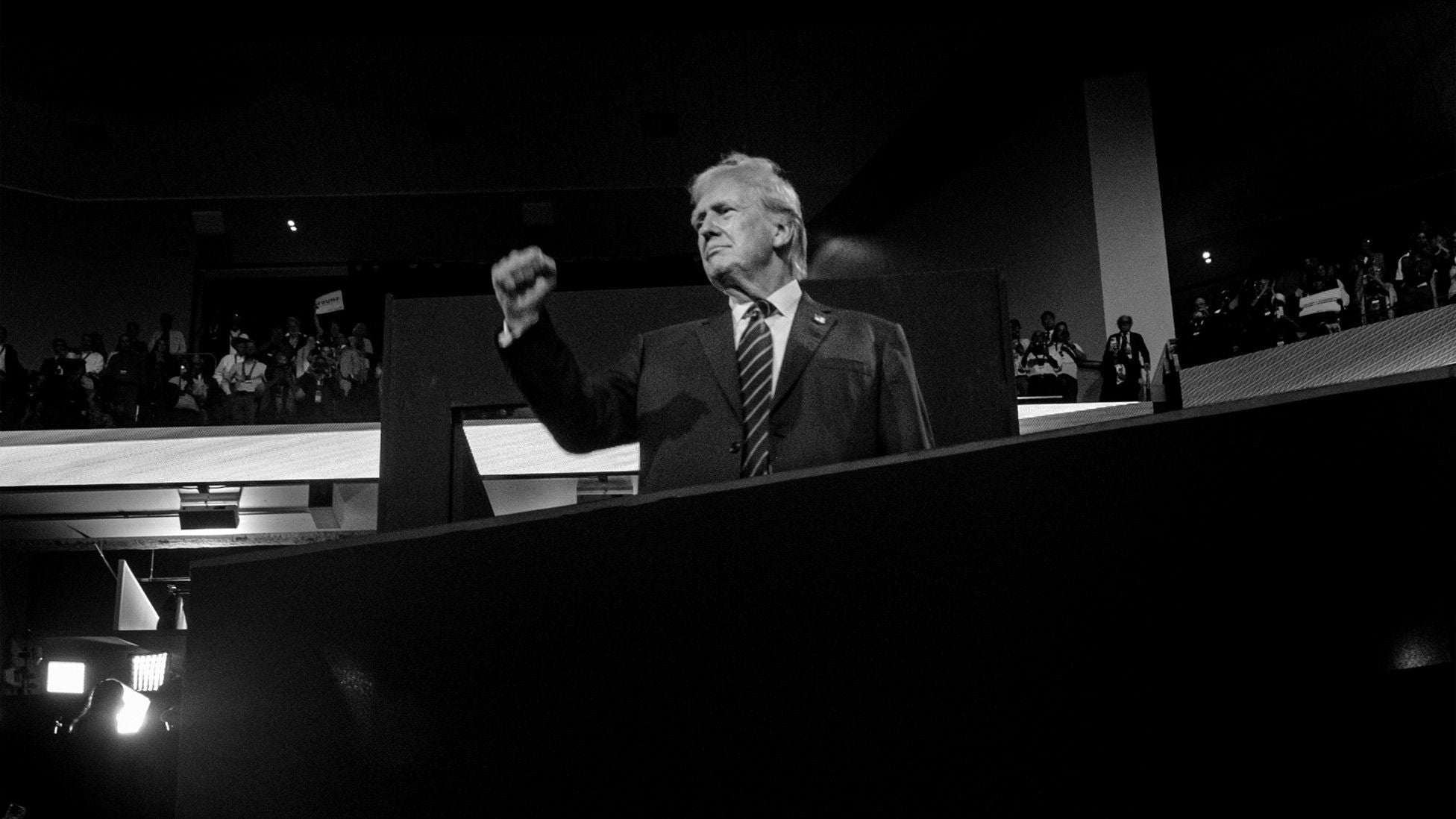 Black-and-white photograph of Donald Trump raising his fist while standing onstage at the 2024 Republican National Convention in Milwaukee.