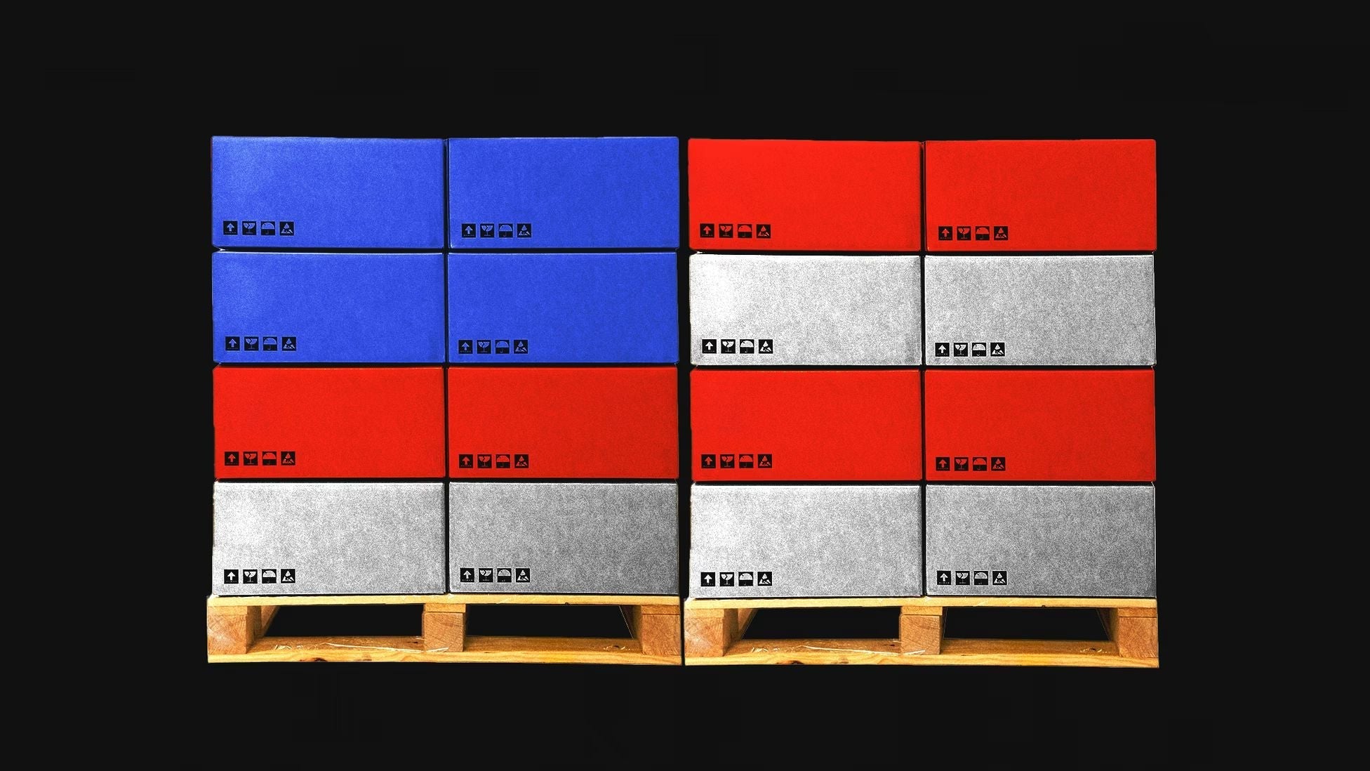 Stacks of color-coded shipping and storage boxes arranged on wooden pallets, illustrating global supply chains, manufacturing logistics, international trade, and the economic infrastructure underpinning modern industrial production.